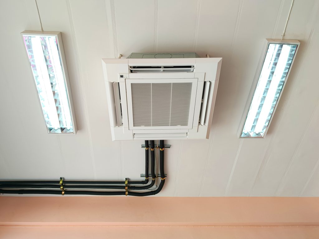 A central air conditioning system installed on the roof of a large hotel with pipes connected to the entire building.